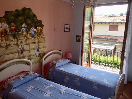 two beds in a room with a mural on the wall at Le Tre Bandiere in Puegnago