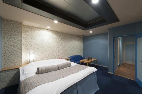 a bedroom with a large bed and a table at ホテル ブランチャペルクリスマス 四日市 in Yokkaichi