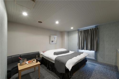 a bedroom with a large bed and a table at ホテル ブランチャペルクリスマス 四日市 in Yokkaichi