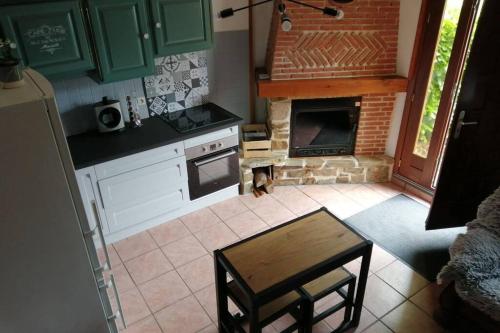 a kitchen with green cabinets and a brick oven at Escapade Normande in Yerville