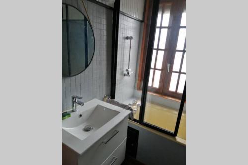 a bathroom with a white sink and a mirror at Escapade Normande in Yerville