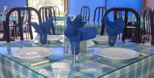 a table with plates and glasses on a blue at San Remo Hotel in Larnaca