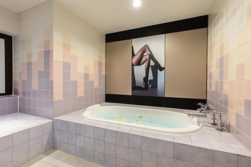 a bathroom with a tub with a pair of feet on the wall at ホテル ブランチャペルクリスマス 四日市 in Yokkaichi