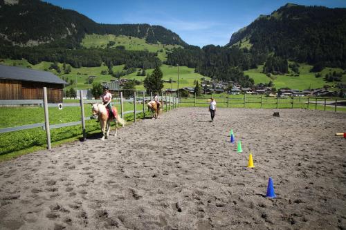 a group of people riding horses on a dirt track at Haus Bergquell in Au im Bregenzerwald