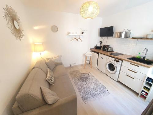 un salon avec un canapé et une cuisine dans l'établissement Home Sweet Home Champs Elysées, à Paris