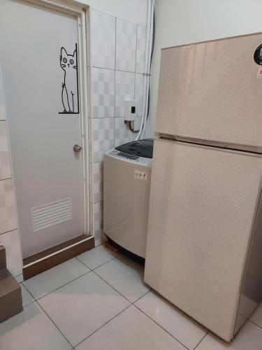 a kitchen with a refrigerator and a cat sticker on the door at 鹿鹿咪民宿 in Lugang