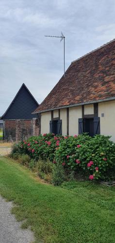 a house with a bunch of flowers in front of it at Gite à la ferme in La Ferté-Saint-Samson