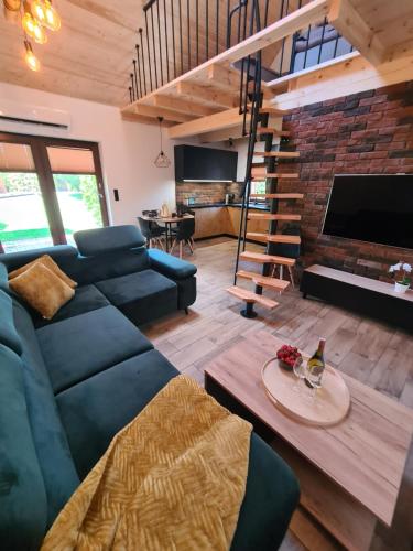 a living room with a blue couch and a fireplace at Ostoja Relaksu Cieciorka in Kaliska