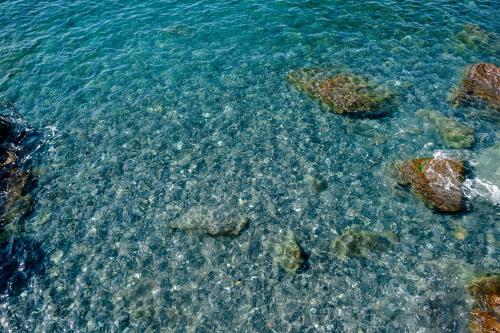 an aerial view of the clear blue water with rocks at Excelsior Palace Hotel in Rapallo