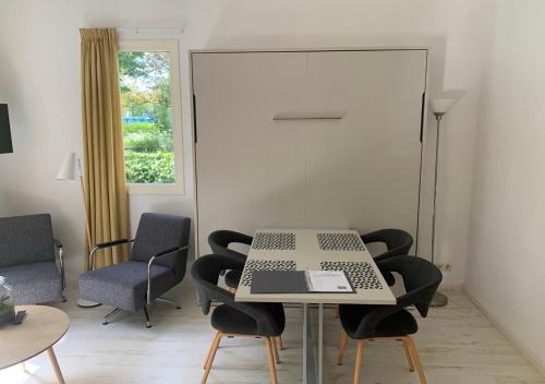 a table with chairs and a laptop on it in a room at Waddenhoes Gastenverblijven in Pieterburen