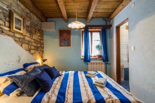 1 dormitorio con 1 cama grande y paredes azules en Rural Pension Istra Partner, en Barban