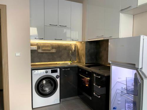 een keuken met een wasmachine en een wasmachine bij Mountain View Magenta White apartment in Sofia