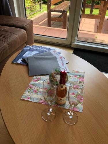 een tafel met twee glazen en een fles wijn bij Ferienhaus Zur Heide - Erdgeschoss in Radibor