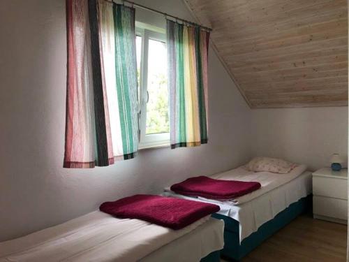 two beds in a room with a window at Białe domki in Jastrzębia Góra