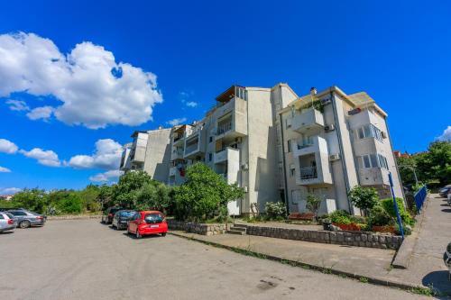 a building with cars parked in a parking lot at Apartment PEK in Crikvenica