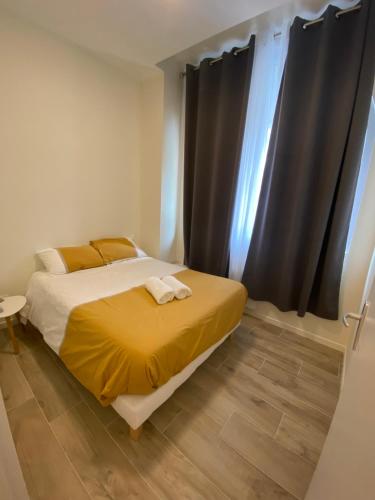 - une chambre avec un lit doté de draps jaunes et une fenêtre dans l'établissement ALBIAPPART HYPER CENTRE, à Albi