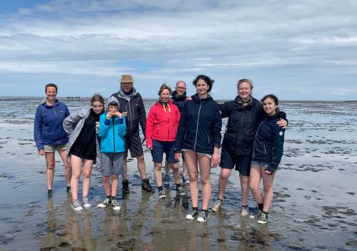 a group of people standing on the beach at Waddenhoes Gastenverblijven in Pieterburen