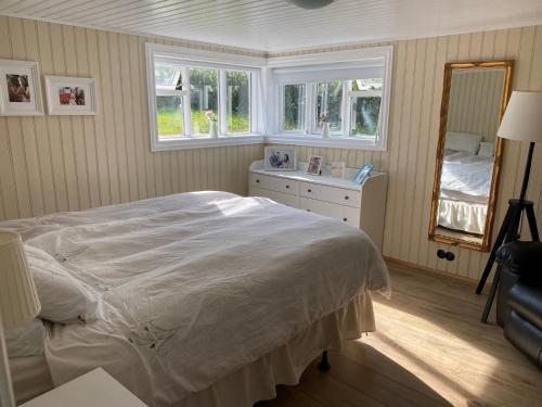 une chambre avec un grand lit et un miroir dans l'établissement Garður restored house, à Stykkishólmur
