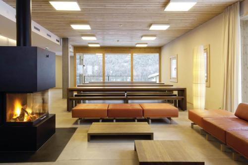 a living room with benches and a fireplace at Scuol Youth Hostel in Scuol