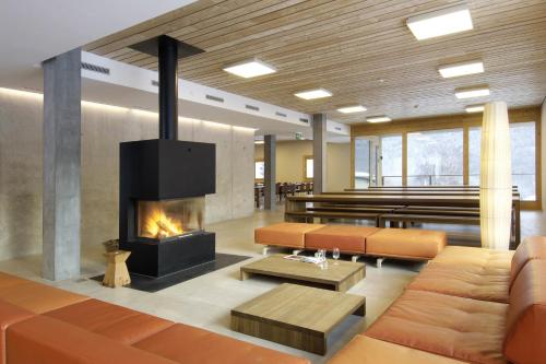 a living room with a fireplace and a couch at Scuol Youth Hostel in Scuol