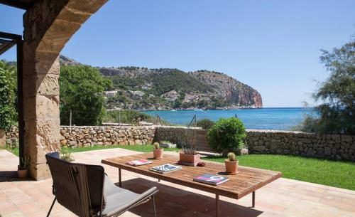 a patio with a table and a view of the ocean at Can Simoneta - Adults Only in Canyamel