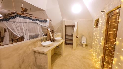 a bathroom with two sinks and a toilet at Milele Villas in Potoa