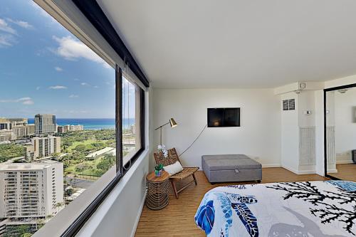 a bedroom with a large window with a view of the ocean at Hawaiian Monarch 203 condo in Honolulu