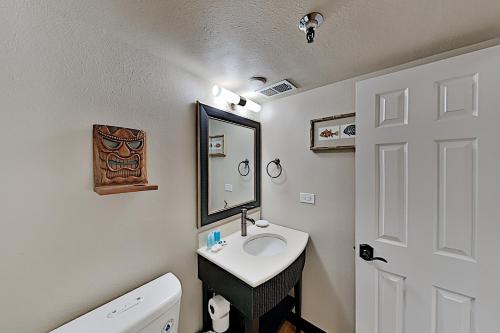 y baño con lavabo, aseo y espejo. en Bamboo 1002 condo, en Honolulu
