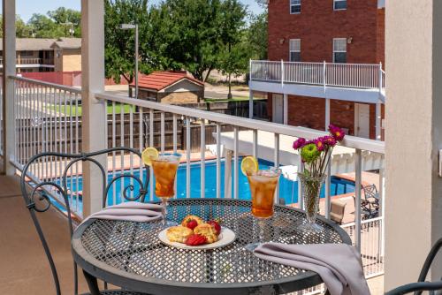 a table with a plate of fruit and drinks on a balcony at Woodrow House Bed & Breakfast in Lubbock