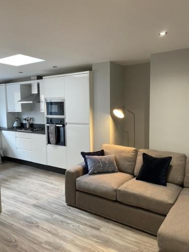 a living room with a couch and a kitchen at Stanley Street Apartment in Southport