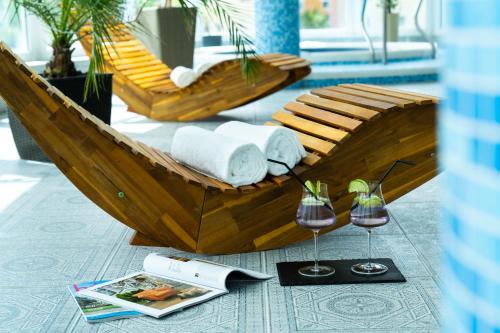 a wooden boat with towels and a glass of wine at Hotel Kristály Konferencia & Wellness in Ajka