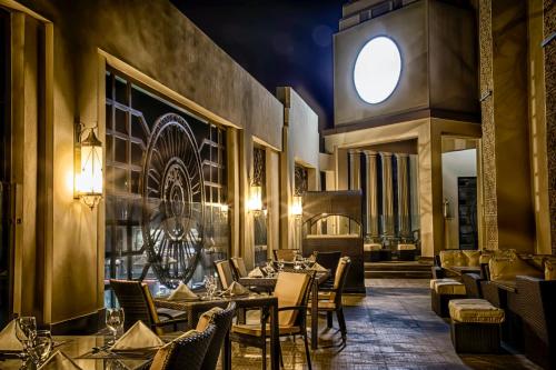 a restaurant with tables and chairs and a round window at Best Western Premier Hotel Gulberg Lahore in Lahore