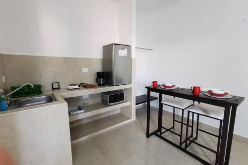 a small kitchen with a table and a sink at Casa en Mahahual cerca de la playa D2 in Mahahual