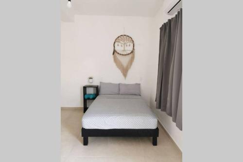 1 dormitorio con cama y cabeza de búho en la pared en Casa en Mahahual cerca de la playa D2 en Mahahual