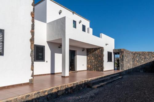 a white house with a wooden deck at Villa Alejandra in Lajares