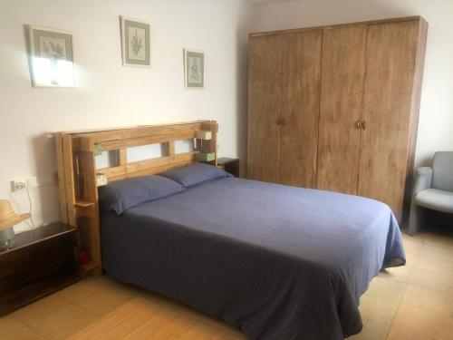 ein Schlafzimmer mit einem Bett mit einem hölzernen Kopfteil in der Unterkunft Vinaros : Maison de Ville à 100m de la plage in Vinarós