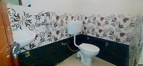 a bathroom with a toilet and a sink at Hotel Comfort Inn Homestay in Dehradun