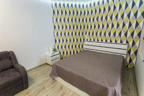 a bedroom with a bed and a chair at Modern apartments in the Centre - Kuznechna str. 26/4 in Kharkiv