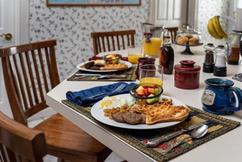 a breakfast table with waffles and eggs and breakfast foods at Woodrow House Bed & Breakfast in Lubbock