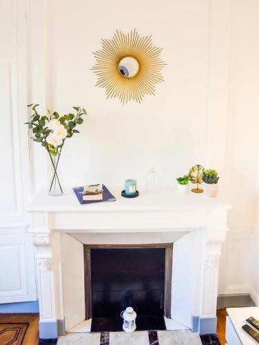 - un salon avec une cheminée et un miroir mural dans l'établissement Le Canyon Rouen Centre by MyFrenchPAT Terrasse & Parking, à Rouen