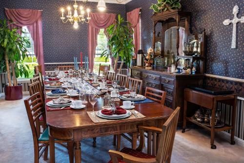 a dining room with a long wooden table and chairs at Woodrow House Bed & Breakfast in Lubbock
