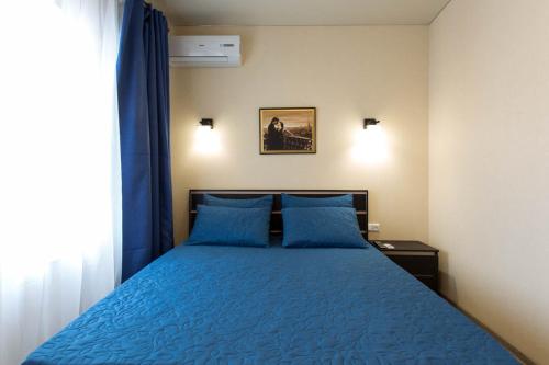 a bedroom with a blue bed with blue pillows at Modern apartments in the Centre - Kuznechna str. 26/4 in Kharkiv