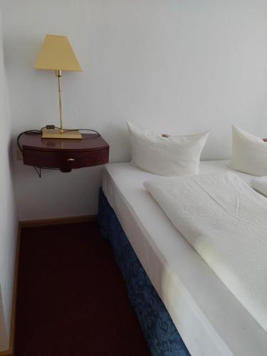 a bedroom with two beds and a lamp on a table at Der Heurige im Gasthaus zum Löwen in Freising