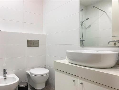 een witte badkamer met een wastafel en een toilet bij Choco House in Setúbal