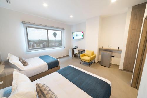 a hotel room with two beds and a desk at TH HOTEL & VIVIENDA in Tepatitlán de Morelos