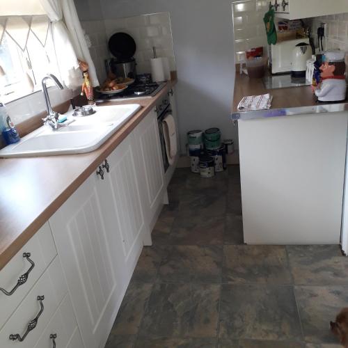 a kitchen with white cabinets and a sink at Blaney house 21 in Newcastle upon Tyne