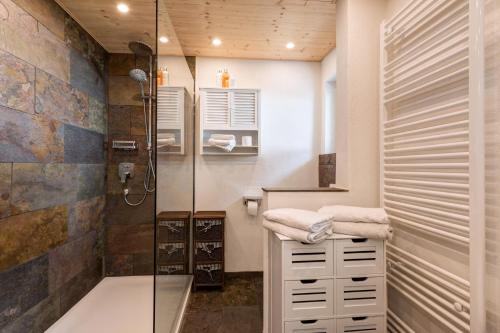 a bathroom with a shower and a sink with towels at Quality Hosts Arlberg - ALPtyrol Appartements in Sankt Anton am Arlberg