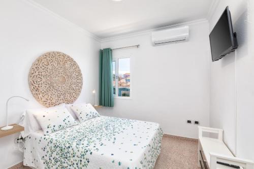 Un dormitorio con una cama y un televisor de pantalla plana. en Casa Dianayer, en El Paso