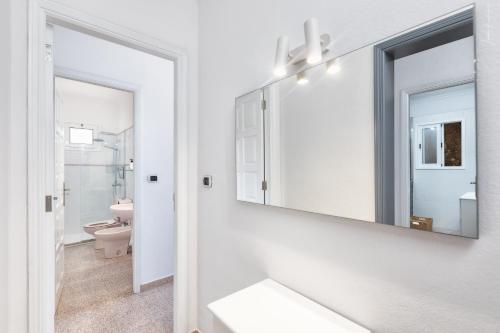 Un baño con espejo y un inodoro. en Casa Dianayer, en El Paso