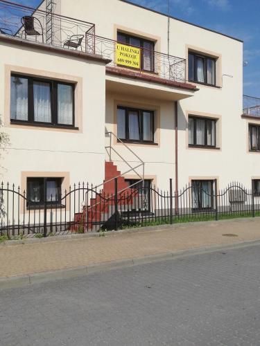 a white building with a yellow sign on it at U Halinki in Darłowo